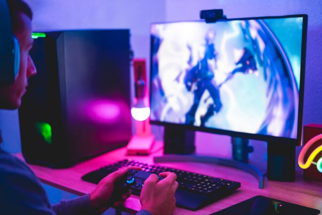 Gamer playing at computer game using joypad