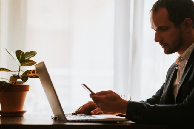 office worker typing on keyboard of laptop indoors