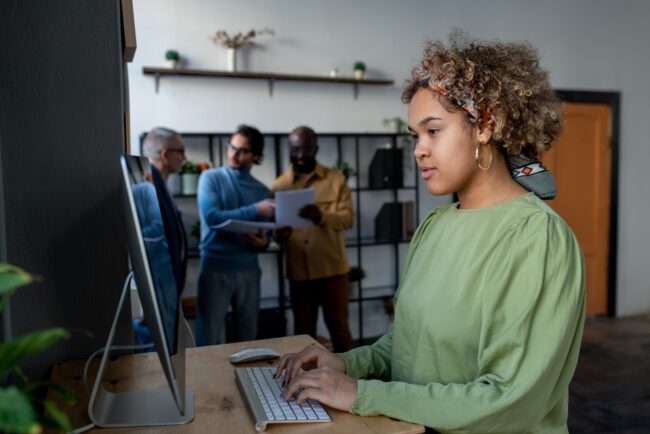 Young pretty biracial businesswoman looking at computer screen