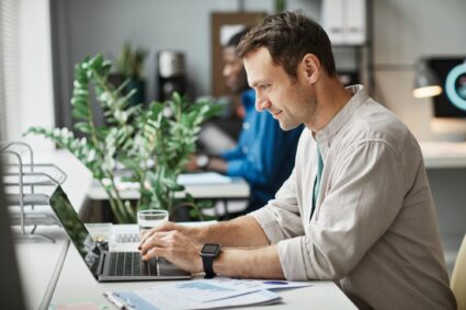 Man Working at Computer in Office Side View